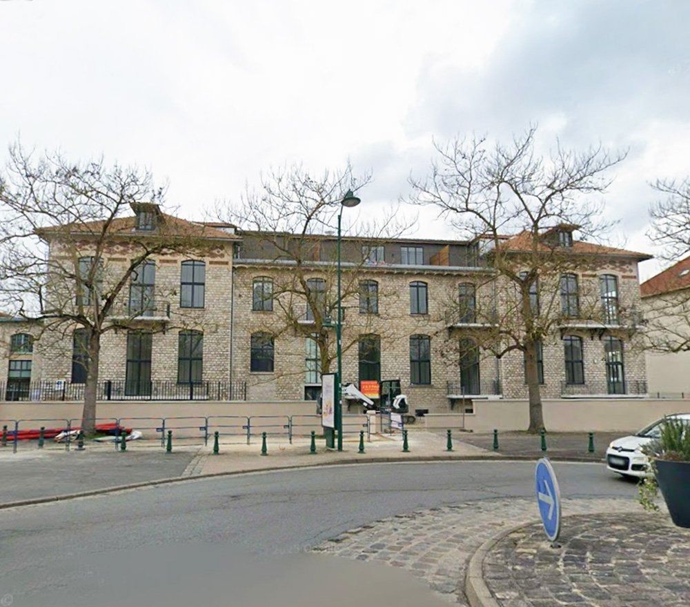 L'ancien immeuble administratif en pierre, avant sa transformation, vu depuis la rue